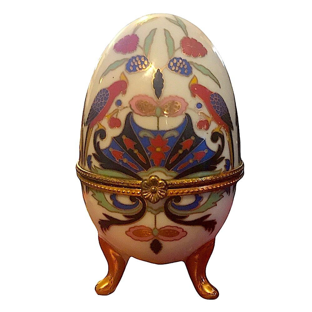 Vintage porcelain egg with bird pattern.